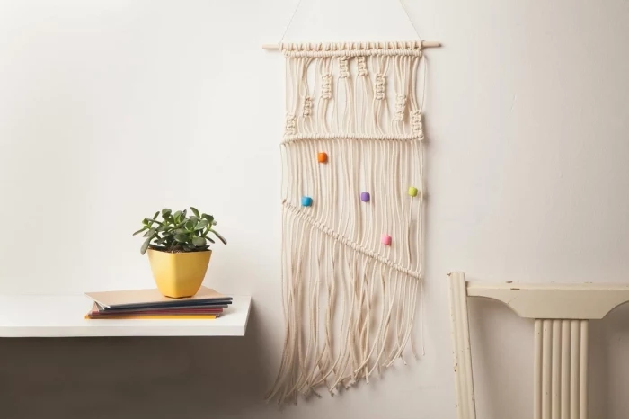 wooden chair, hanging white wooden shelf, potted succulent, macrame wall art, white wall