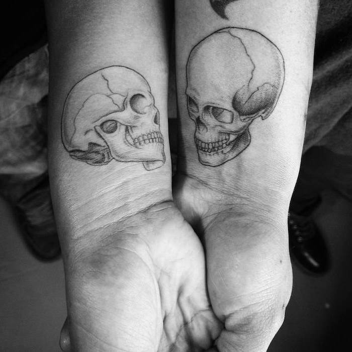 two skulls, wrist tattoos, black and white photo, unique couple tattoos