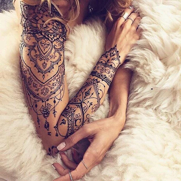 mandala arm sleeve tattoo, girl chest tattoos, white furry blanket, blonde hair