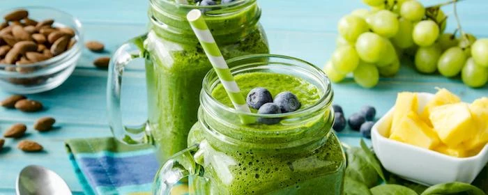 green smoothies, in jars, blackberries on top, how to make a smoothie with frozen fruit, green and white paper straws