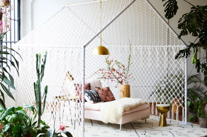 large tent, made of macrame, light pink bed, how to do macrame, potted plants, colourful throw pillows