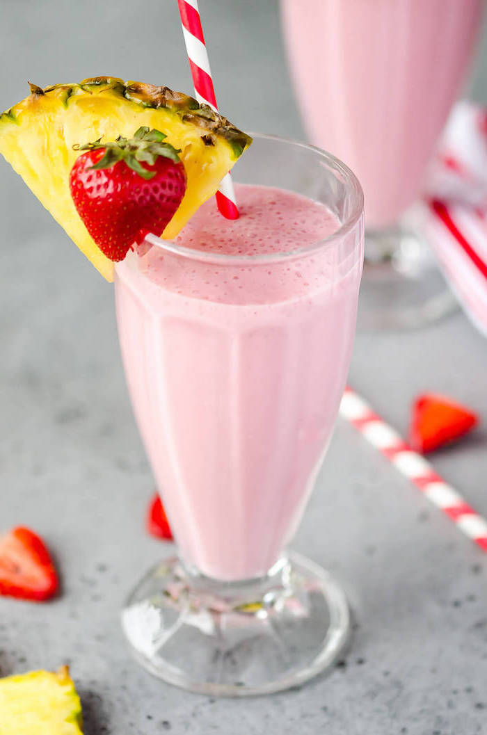 red and white paper straws, pineapple and strawberry on the rim, milkshake glass, smoothie recipes with frozen fruit