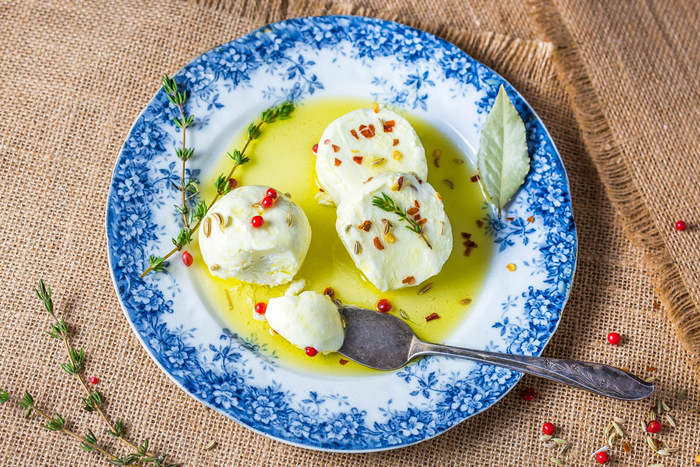 easy vegetarian appetizers, sliced mozzarella, in a blue and white plate, with herbs and sauce
