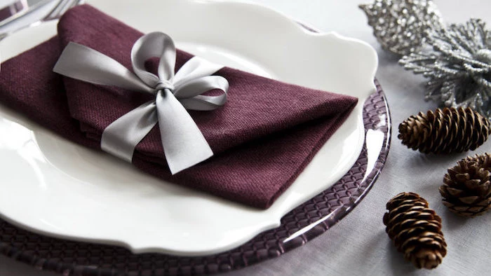 purple napkin, folded as an envelope, grey ribbon around it, how to fold napkins, white and purple plates