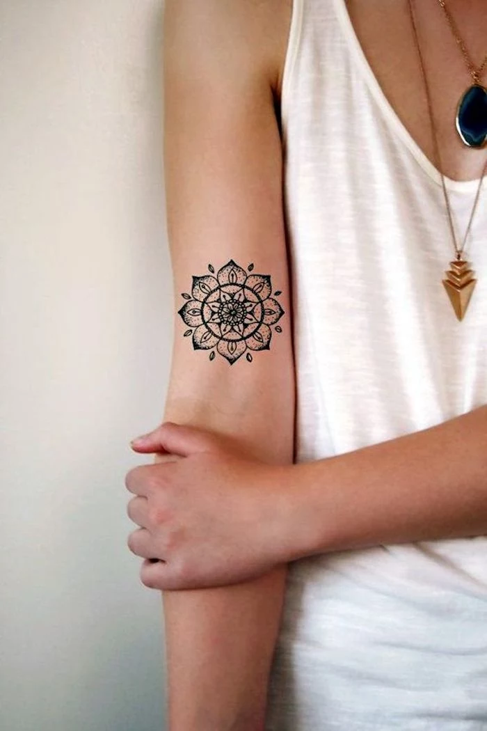 white top, leg tattoos for girls, mandala inside arm tattoo, white background, gold necklaces