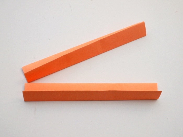 orange paper, folded in two, on a white background, dun indoor games for kids, step by step, diy tutorial