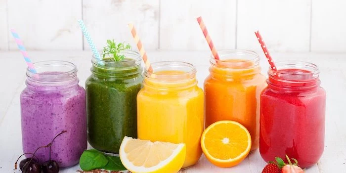 different smoothies, in jars, how to make healthy smoothies, colourful straws, sliced fruits