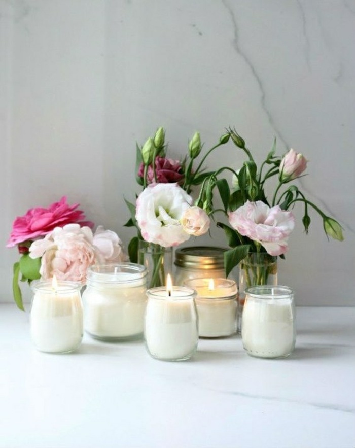 small peony flower bouquets, mason jar candles, small jars, on a marble countertop