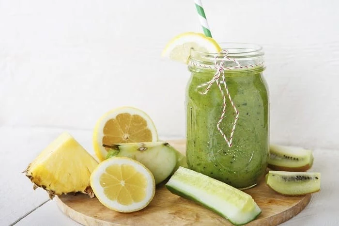 sliced cucumber and kiwi, apple and pineapple, how to make healthy smoothies, wooden cutting board