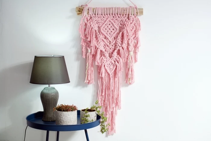 pink wall decoration, blue metal table, potted plants, white wall, how to do macrame