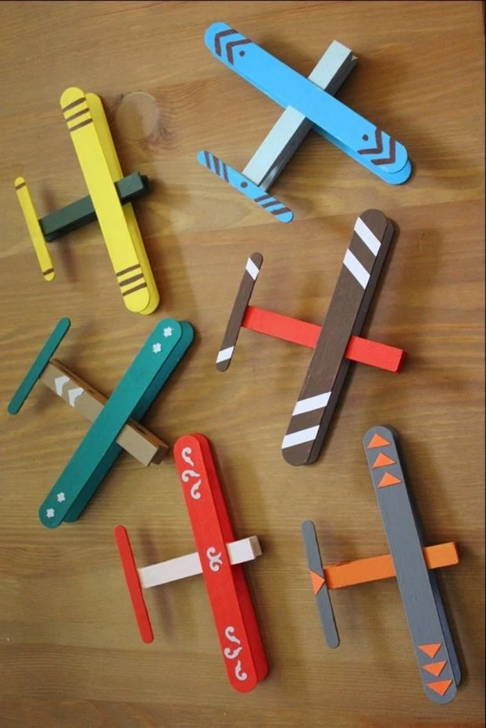 colourful aiplanes, made of popsicle wooden sticks, pre k learning games, wooden table