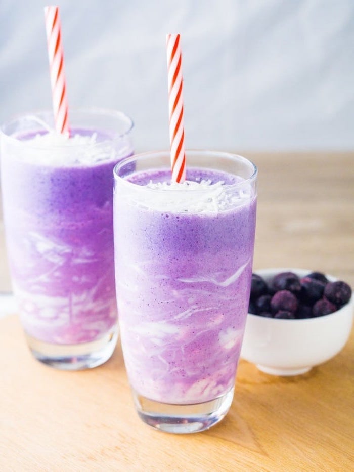 purple and white layered smoothie, fruit smoothie recipes, red and white straws, berries in a bowl