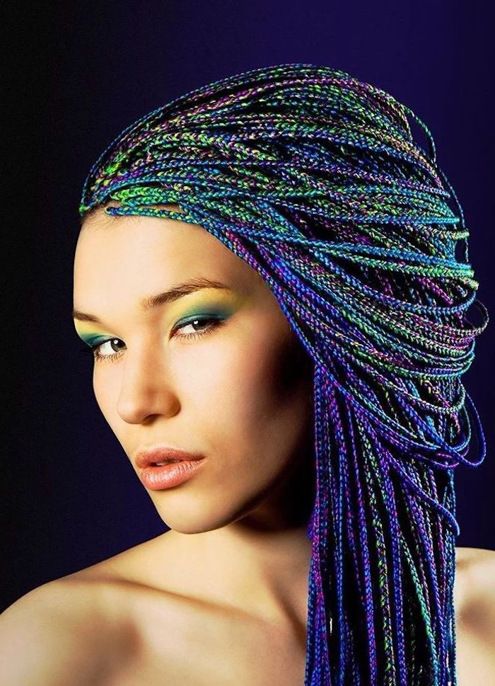 cute braid styles, rainbow coloured hair, woman standing in front of a blue background