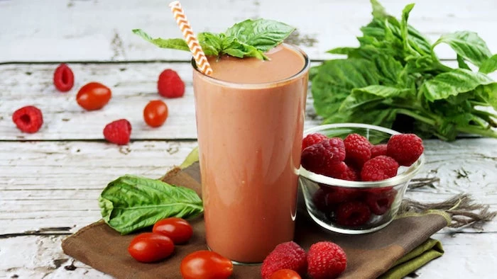 raspberries in a bowl, cherry tomatoes, basil leaves, how do you make a smoothie, wooden table