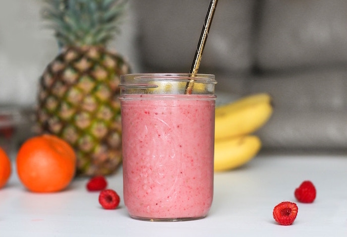 pineapple and bananas, gold paper straw, how do you make a smoothie, raspberries on the table