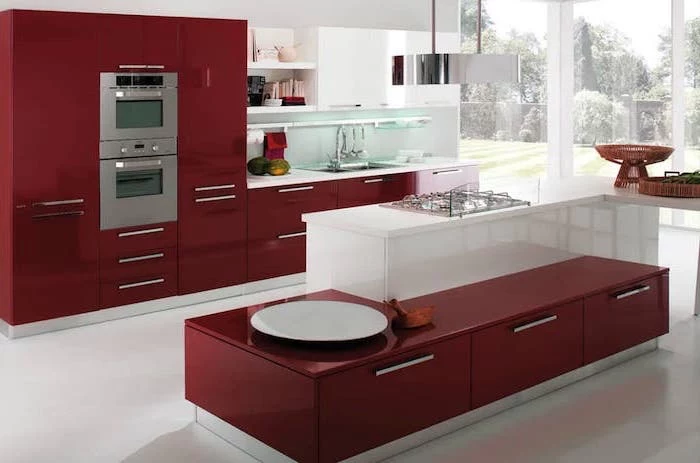 kitchen island with bar seating, red cabinets and drawers, white floor, large windows