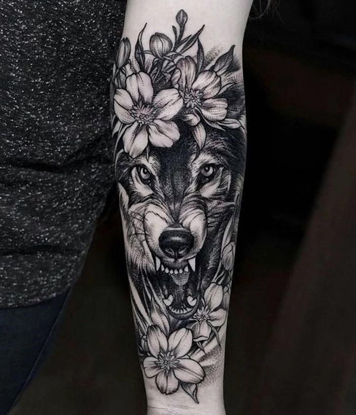 roaring wolf, surrounded by flowers, small tattoos with meaning, grey top