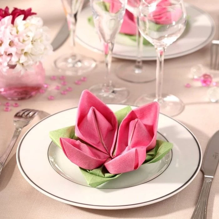 rose shaped, pink and green napkins, on a white plate, how to fold napkin fancy, small bouquet