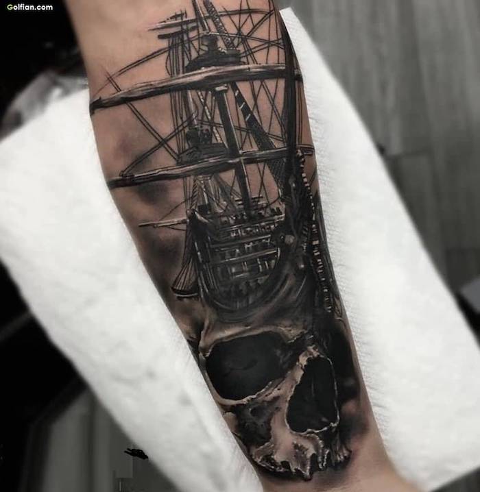 sailing ship, skull underneath, cool arm tattoos, hand on white paper
