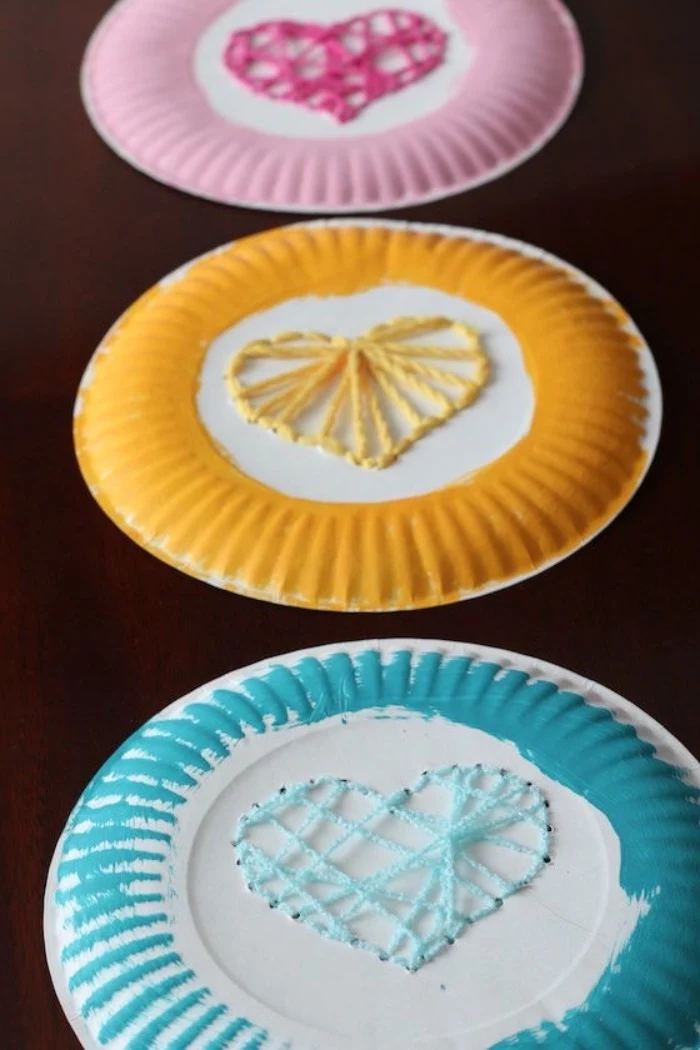 preschool classroom games, paper plates, painted in pink, yellow and blue, hearts made of strands