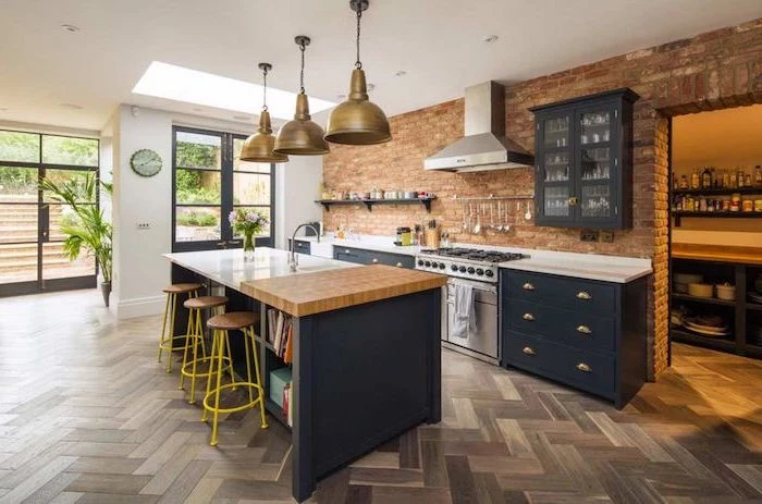 brick wall, grey cabinets and drawers, white countertops, kitchen island with bar seating, yellow metal bar stools