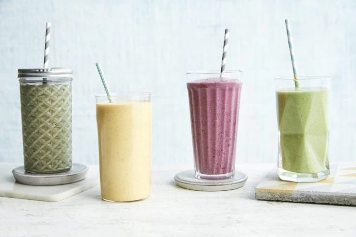 tall glasses, filled with different smoothies, ceramic coasters, peanut butter banana smoothie