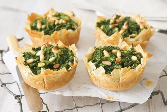 bread bowls, filled with spinach and nuts, vegetarian finger food, on a metal stand