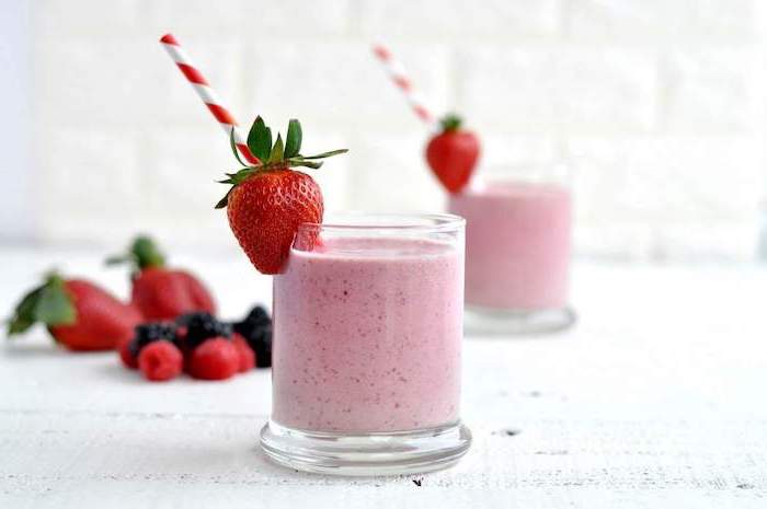 healthy breakfast smoothie recipes, red and white straws, strawberries on the rim