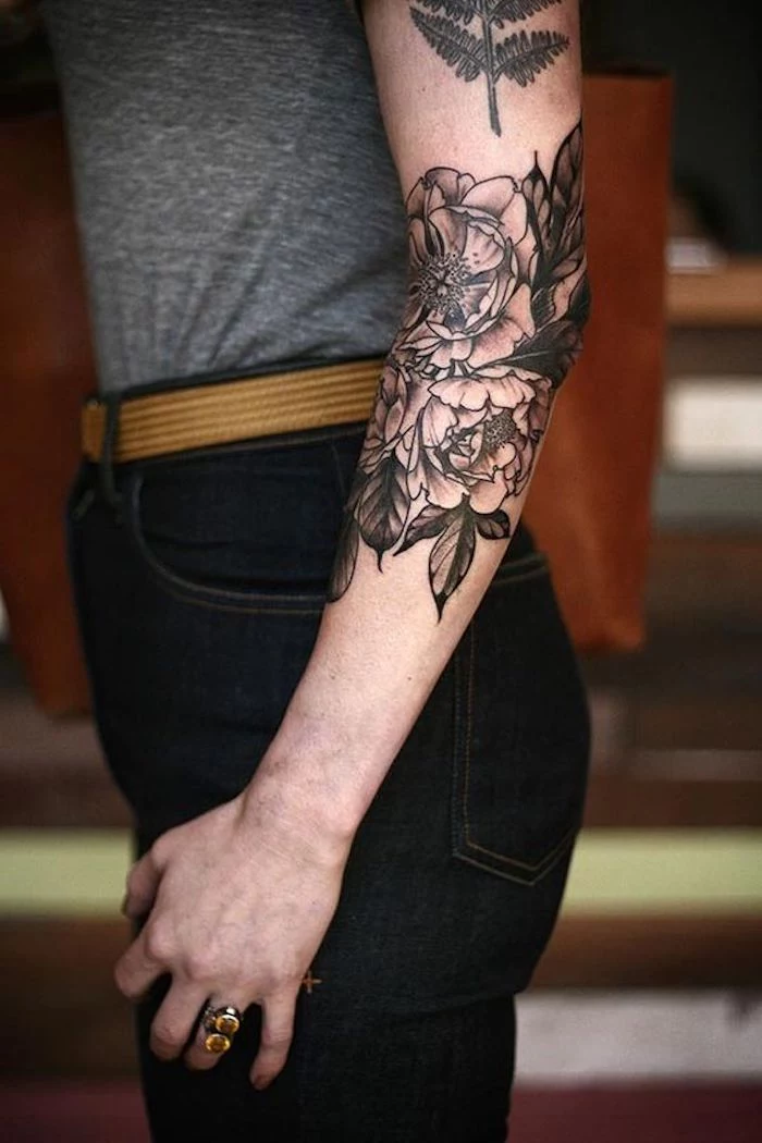 meaningful tattoo ideas, roses elbow tattoo, grey top, black jeans