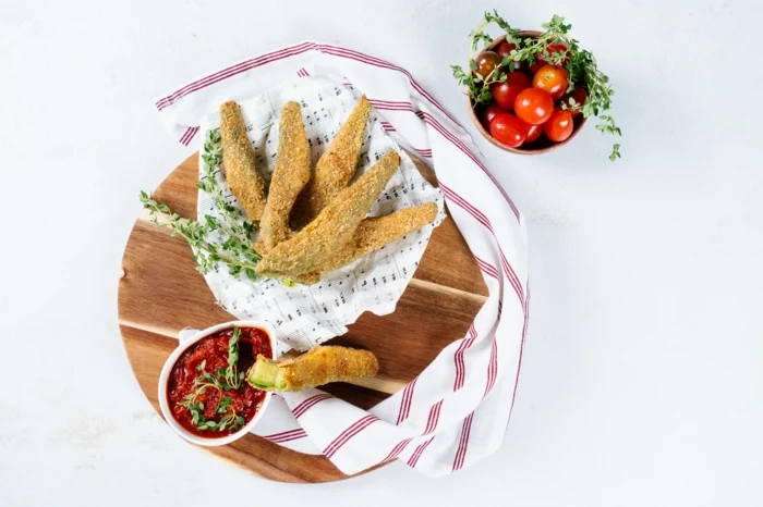 avocado fries recipe, inside wooden bowl, tomato sauce and cherry tomatoes in small bowls