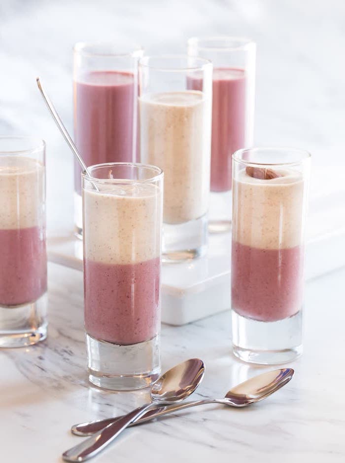 layered smoothies, in tall glasses, two spoons, peanut butter and banana smoothie, marble countertop