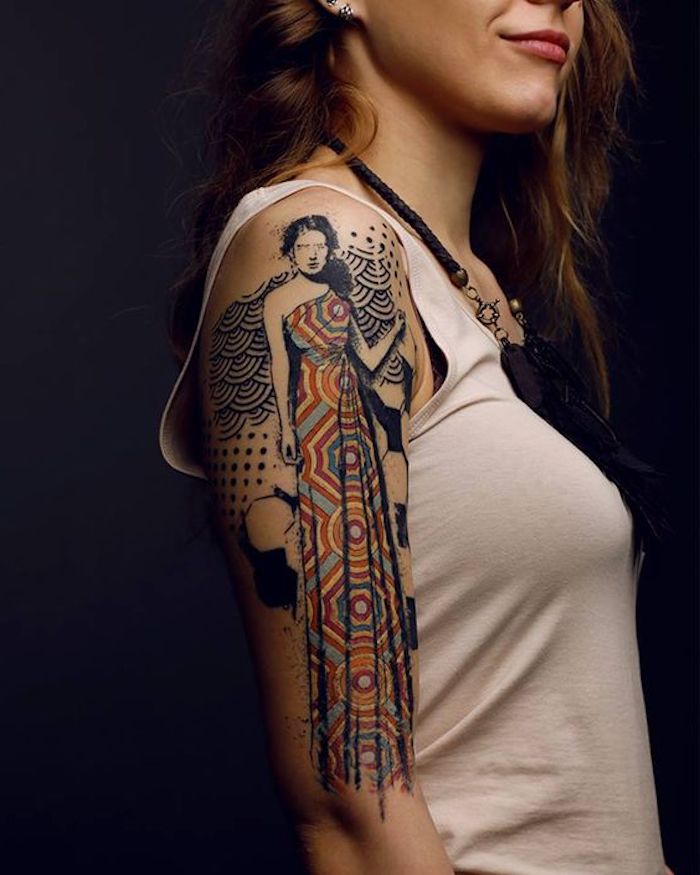 woman with a long colourful dress, shoulder tattoo, tattoos with deep meaning, white top, black background