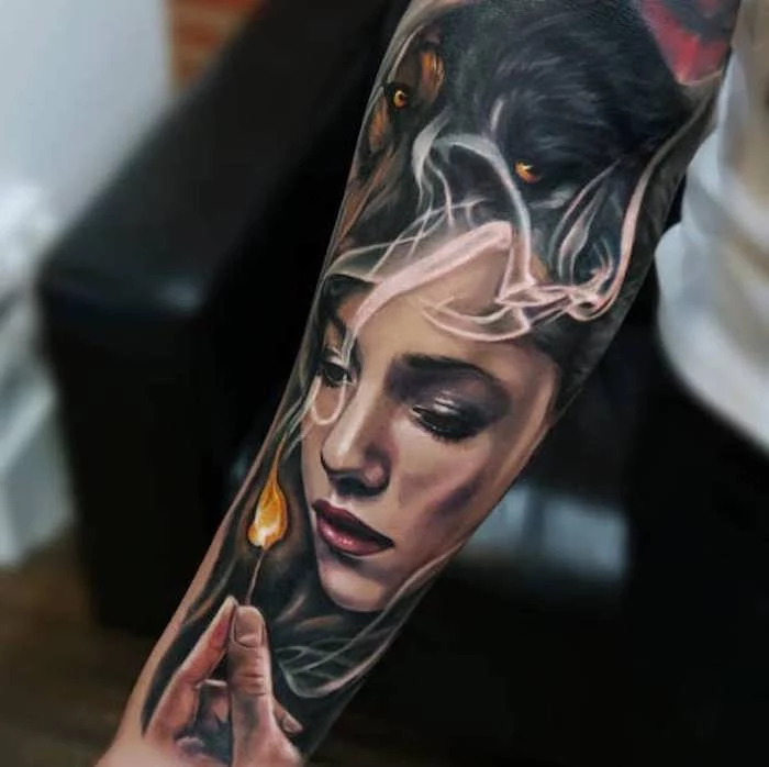 woman with a wolf head, holding a lit match, forearm tattoo, meaningful tattoos