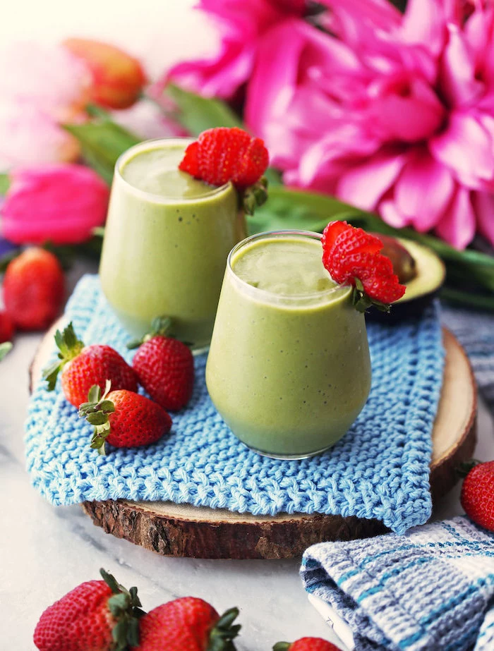 blue knitted cloth, on a wooden board, how to make a green smoothie, strawberries on the rims