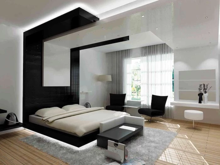 black and white tiled accent wall, wooden floor, grey carpet, how to decorate room, black armchairs