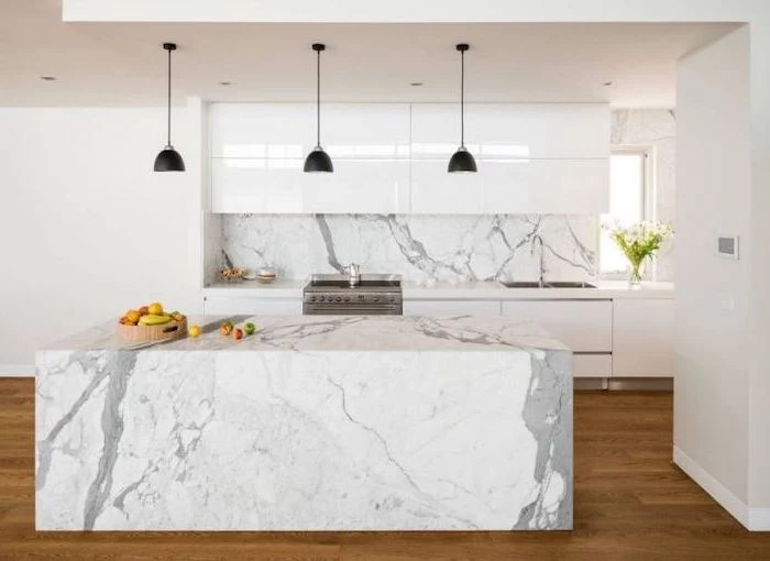 marble kitchen island and backsplash, wooden floor, pictures of kitchen islands, white cabinets
