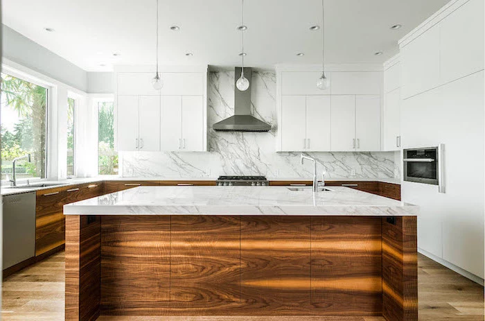 marble countertops and backsplash, white and wood cabinets, kitchen island with sink