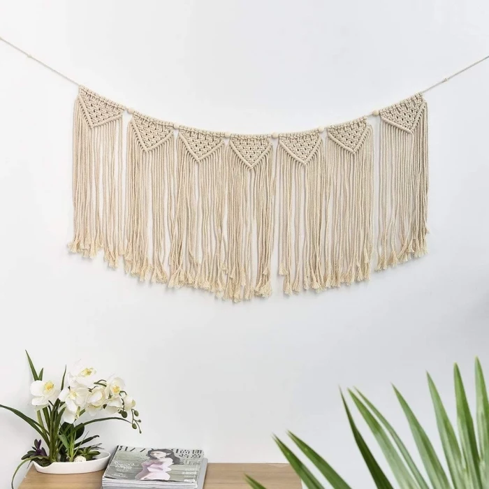 white wall, stack of magazines, learn macrame, white orchids, wooden table