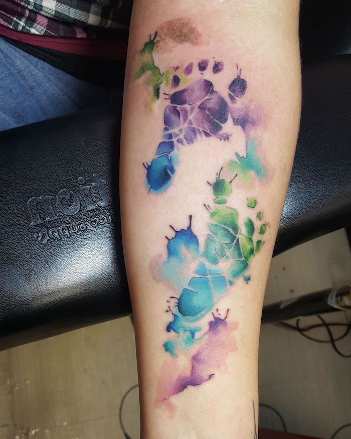 baby's footprints, forearm tattoo, watercolor tattoo, black leather chair