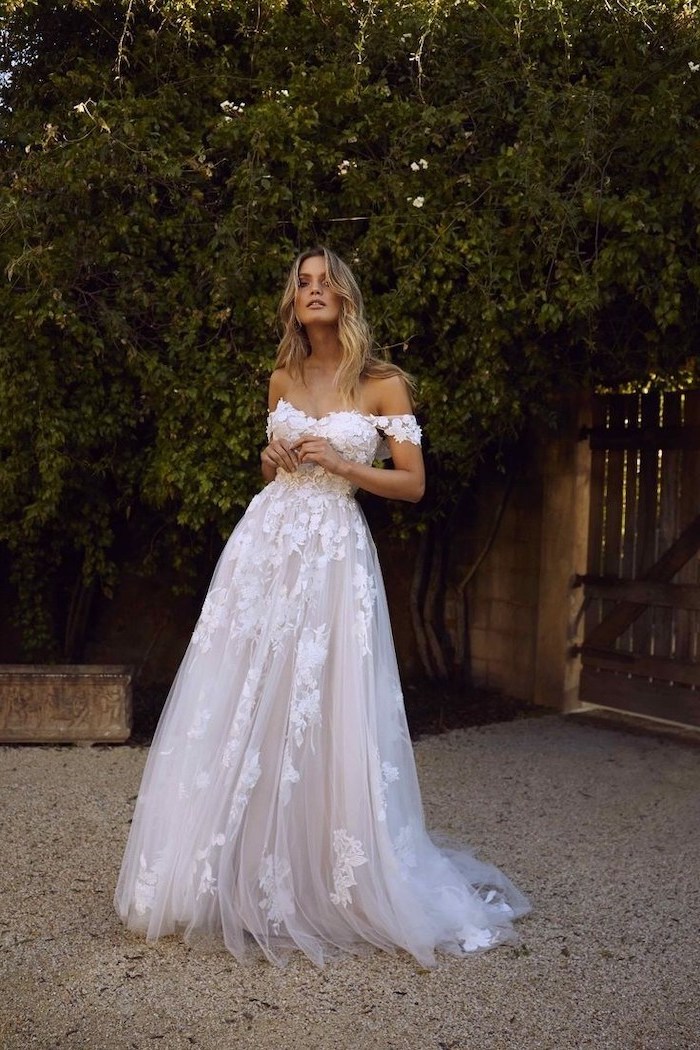 long blonde wavy hair, white dress, made of lace and tulle, off the shoulder neckline, beach wedding dresses