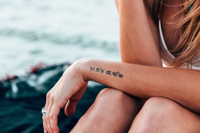 geographical coordinates, side arm tattoo, tattoo placement, blonde hair, white top