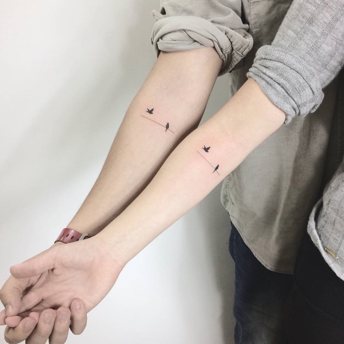 inner bicep tattoo, matching couple tattoos, two birds, forearm tattoos, grey shirt and blouse