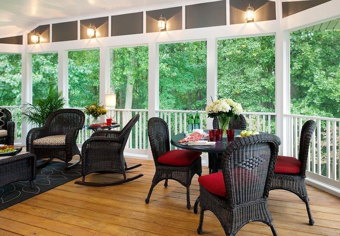 black armchairs, red and grey cushions, front porch furniture, flower bouquets, screened in porch