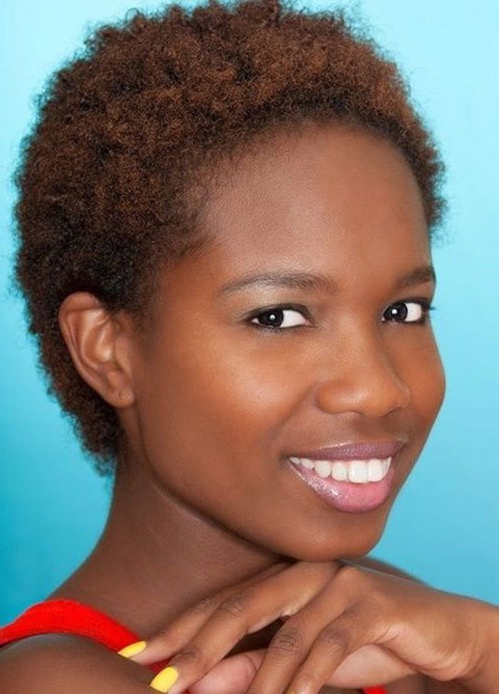 blue background, woman smiling, short hair, african american short hairstyles, yellow nail polish