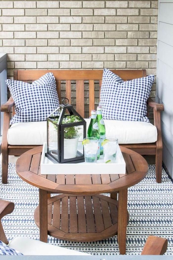 wooden bench and table, white cushions, blue and white throw pillows, brick wall, front porch decorating ideas