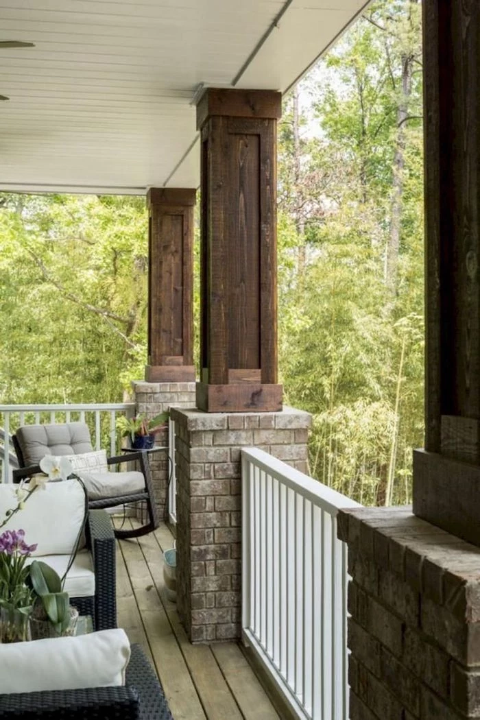 brick and wood columns, wooden railing, front porch decorating ideas, garden furniture, grey cushions