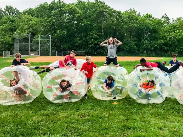 boys playing, on a green glass field, birthday party ideas for teens, bubble balls