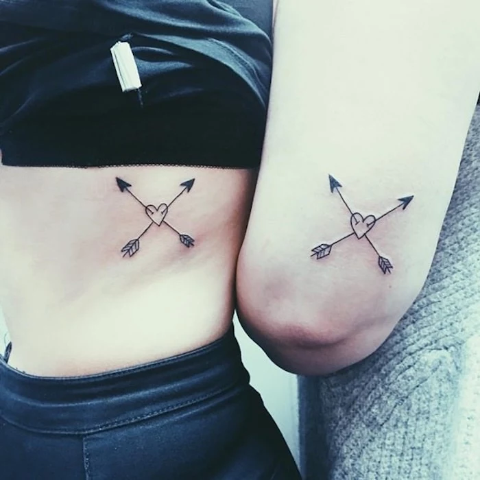 crossed arrows, hearts in the middle, matching friend tattoos, rib cage tattoo, back of arm tattoo