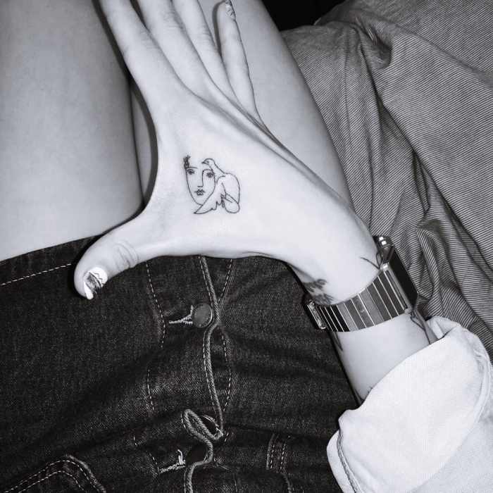 cute tattoos for girls, female face and bird, hand tattoo, black and white photo, denim skirt