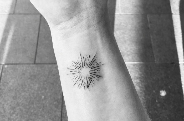 dotted sun, key tattoos, black and white photo, wrist tattoo, tiled floor